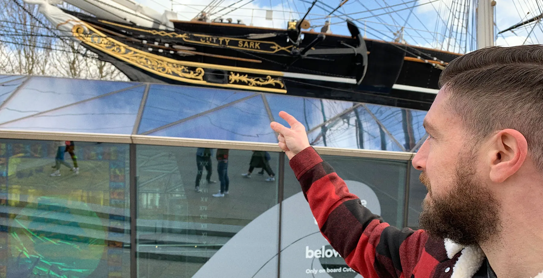 Pointing at the Cutty Sark's gilded stern for logo inspiration